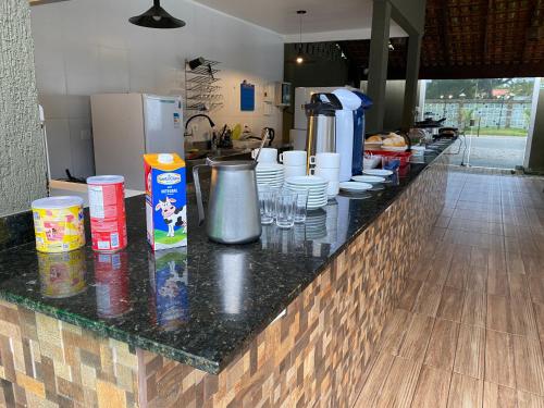 a kitchen with a counter with cups and dishes on it at Pousada Pontal do Sul in Pontal do Paraná