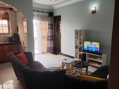 a living room with a couch and a television at safari chic retreat in Kampala in Kampala