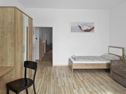 a bedroom with a bed and a chair in it at CityApt Wolfik Stockerau in Stockerau