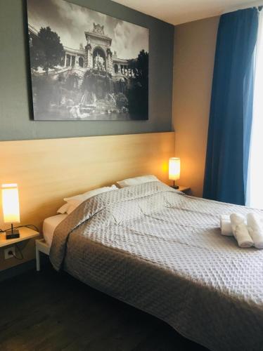 une chambre avec un lit avec deux lampes et un tableau dans l'établissement Bord de mer! Studio Terrasse ,Prado Plage, à Marseille