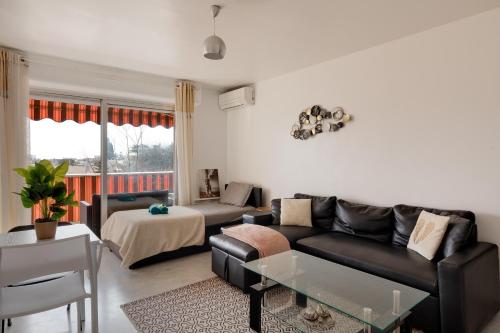 un salon avec un canapé et une table dans l'établissement Piscine, Antibes , calme et ensoleillé, à Antibes