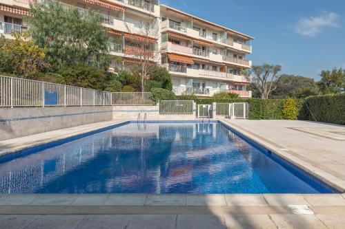 une piscine vide en face d'un bâtiment dans l'établissement Piscine, Antibes , calme et ensoleillé, à Antibes