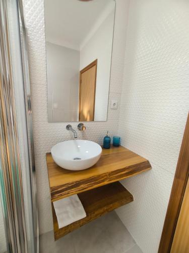 a bathroom with a sink and a mirror at Unmei in Lagoa