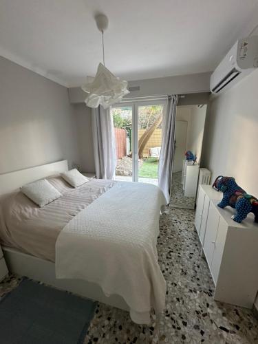 une chambre avec un lit blanc et une fenêtre dans l'établissement T2 with garden and parking, à Cannes