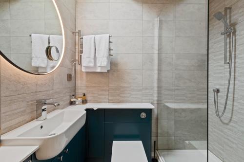 a bathroom with a sink and a mirror and a tub at Canaston Oaks in Narberth