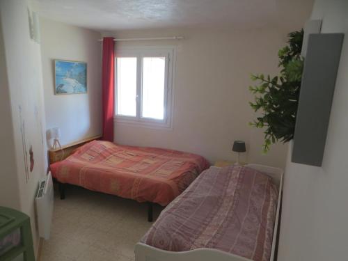 une chambre avec deux lits et une fenêtre dans l'établissement Logement au calme au sein de la provence verte, à Seillons-Source-dʼArgens