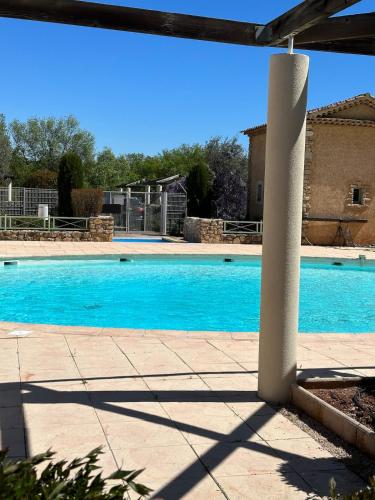 - une piscine dans une cour avec une piscine bleue dans l'établissement Compact vacation house in Vidauban, à Vidauban