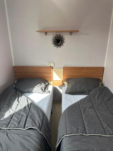 two beds in a small room with at MOBIL HOME Le Soleil,3CH,6PERS in Port-la-Nouvelle