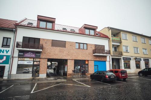 a building with cars parked in a parking lot at Castle Apartments in Zvolen