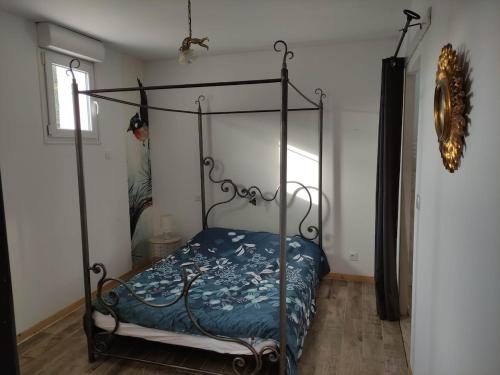 - une chambre avec un lit en métal et une couette bleue dans l'établissement Appartement T2 en campagne, à Sarrians