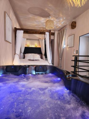 - une baignoire dans une chambre avec un lit dans l'établissement Loveroom Romantique La Mure, à La Mure