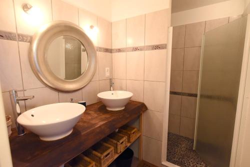 une salle de bain avec un lavabo et un miroir sur un comptoir dans l'établissement WHITE BLUE House, à Biscarrosse