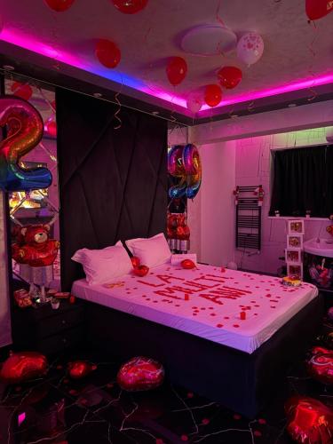 a bedroom with a large bed with red balloons on it at Relax Regim Apartament in Bucharest