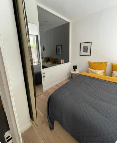 une chambre avec un lit et un grand miroir dans l'établissement Un jardin place de la Comédie, à Montpellier