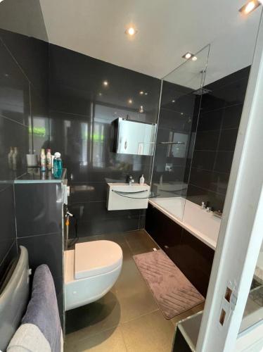 une salle de bain avec toilettes, baignoire et lavabo dans l'établissement Un jardin place de la Comédie, à Montpellier