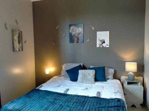 a bedroom with a bed with blue and white pillows at Maison proche Etretat, Le Havre in Montivilliers
