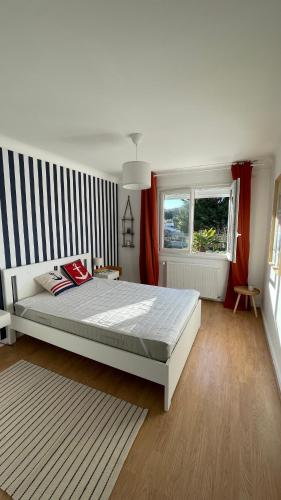 - une chambre avec un grand lit et un mur rayé dans l'établissement Maison proche de la plage et du port !, au Croisic