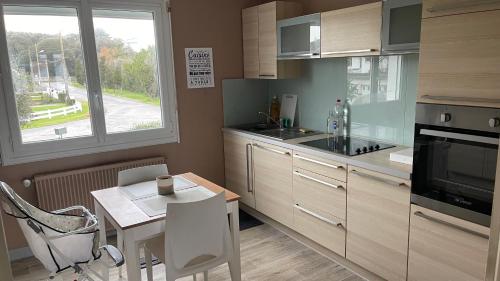une cuisine avec une petite table, une table et une fenêtre dans l'établissement Maison proche de la plage et du port !, au Croisic