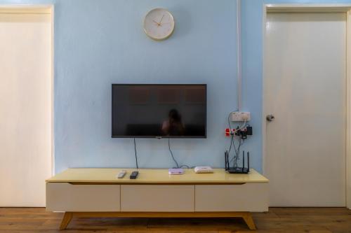 a living room with a tv on a blue wall at Premium Bajet#2 Queen bed 1 Single 1 Sb#Batu Kawan#Penang in Simpang Ampat