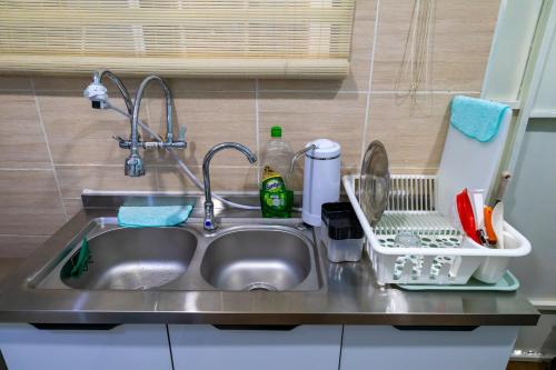 a kitchen sink with a dish drying rack next to it at Premium Bajet#2 Queen bed 1 Single 1 Sb#Batu Kawan#Penang in Simpang Ampat