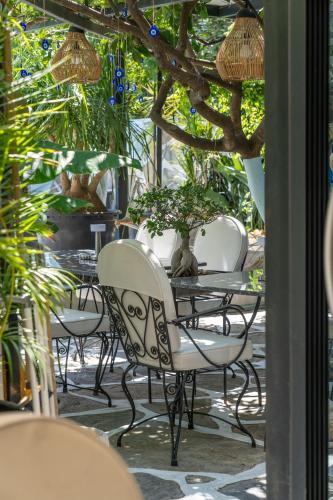 a patio with chairs and a table with plants at Artunc Hotel Bodrum in Bodrum City