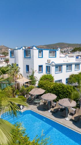 a view of a hotel with a pool and umbrellas at Artunc Hotel Bodrum in Bodrum City