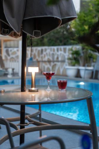 a table with two glasses and a lamp on it at Artunc Hotel Bodrum in Bodrum City