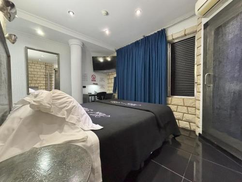 a bedroom with a bed and a blue curtain at Hotel Plata in Ibi