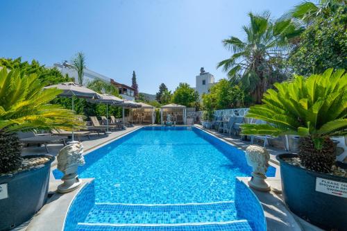 a swimming pool with blue water in a resort at Artunc Hotel Bodrum in Bodrum City