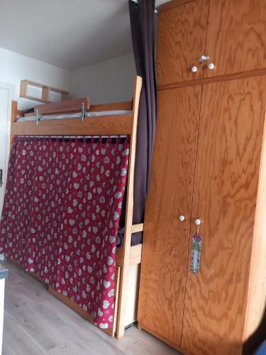 - une chambre avec des lits superposés et un rideau rouge dans l'établissement Studio cabine 4 couchages vue sur les pistes, à Puyvalador