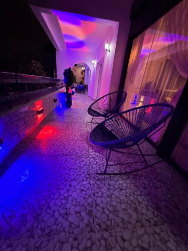 a room with purple and blue lights and two chairs at Riad le marin Coucou beach in Agadir