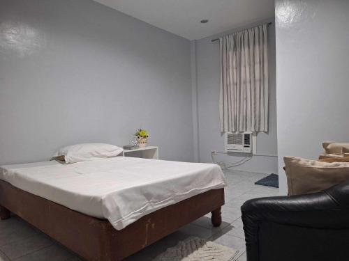 a white bedroom with a bed and a chair at Lymen's Apartment in Cordova