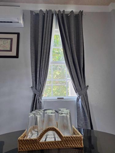 a window with gray curtains and glasses on a table at Lymen's Apartment in Cordova