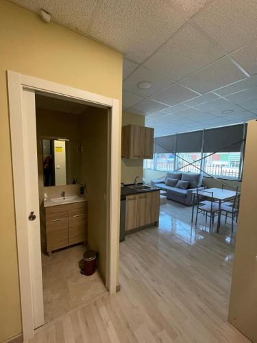 a kitchen and living room with a couch and a table at Estudios 85 - Cerca de Madrid, Toledo y Parque Warner in Parla