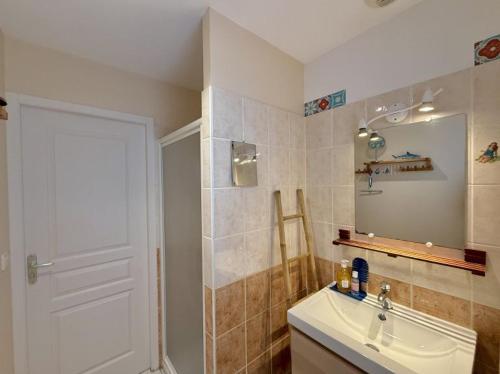 une salle de bain avec un lavabo et un miroir dans l'établissement La Maison Siméon, à Amboise