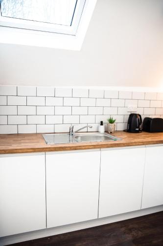 a kitchen with white cabinets and a sink at Converted bank centre of Holmfirth -split apartment, Bronte- Archive in Holmfirth