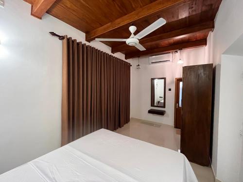 a bedroom with a bed and a ceiling fan at Lagoon Bliss in Ahangama