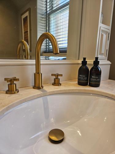 a bathroom sink with two soap bottles on a counter at Craggan in Ballater