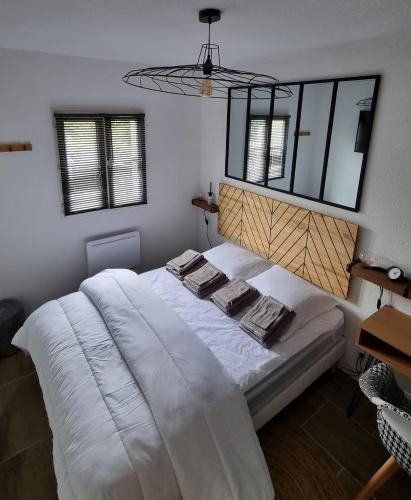 une chambre avec un lit blanc avec deux serviettes dessus dans l'établissement Appartement 400m de la mer, à Dolus-d'Oléron
