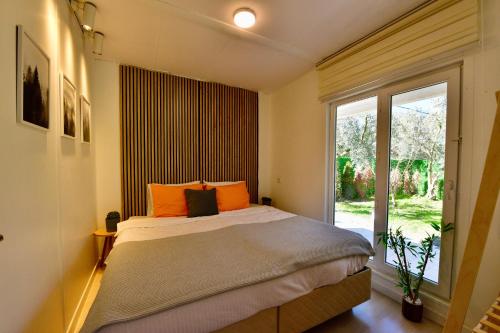 a bedroom with a bed with orange pillows and a window at İZNİK Lake Olive villa in İznik