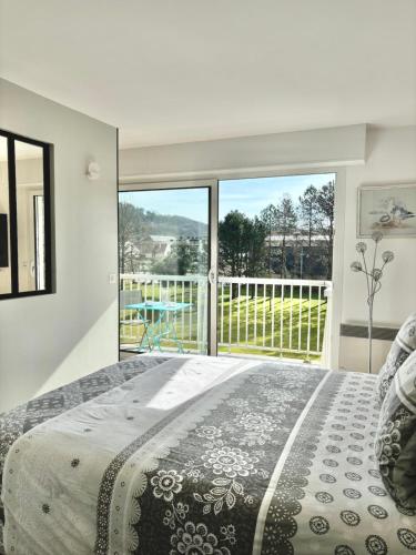 une chambre avec un lit et une grande fenêtre dans l'établissement Les charmes Du Bosquet Parc d'Amour et Nature Parking Privé Sécurisé, à Étretat