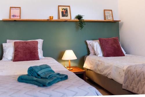 two beds with towels on them in a room at Seaview Ensuite rooms in Sagres centre - Casa Maluka in Sagres