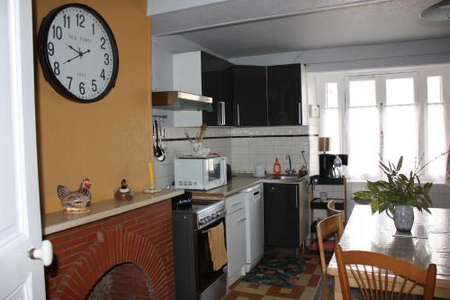 une cuisine avec une horloge accrochée au mur dans l'établissement La Gâtinaise, à Châtillon-Coligny