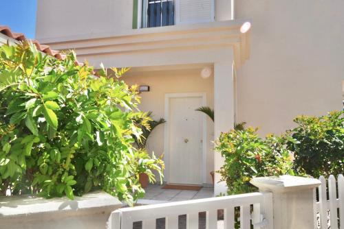 a white door leading into a building with plants at Pura Vida by Maspalomas Holiday Villas in Pasito Blanco
