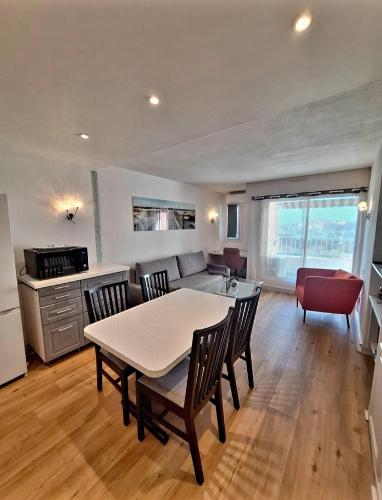 une cuisine et un salon avec une table et des chaises dans l'établissement Superbe appartement climatisé, résidence avec piscine, proche des commerces et du port, au Cap d'Agde