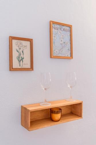 two wine glasses on a wooden shelf on a wall at Seaview Ensuite rooms in Sagres centre - Casa Maluka in Sagres
