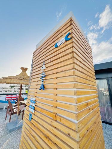 a wooden wall next to a chair and an umbrella at Riad le marin Coucou beach in Agadir