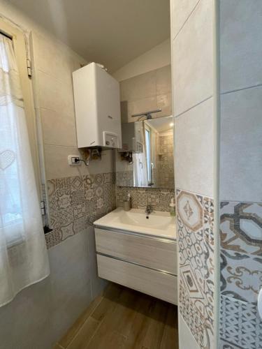 a bathroom with a sink and a mirror at Appartamento Beatrice in Castellammare di Stabia