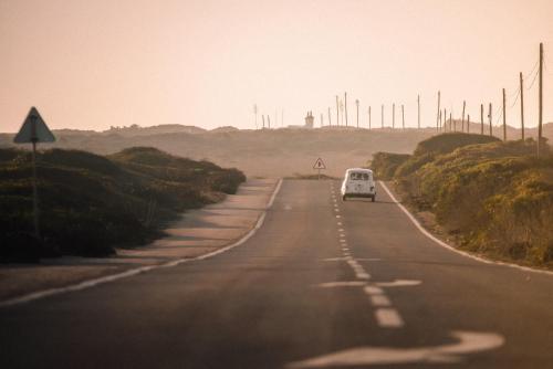 a van is driving down a road at Seaview Ensuite rooms in Sagres centre - Casa Maluka in Sagres