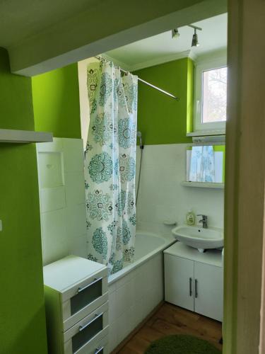a bathroom with a bath tub and a sink at Cirilla Home in Szombathely
